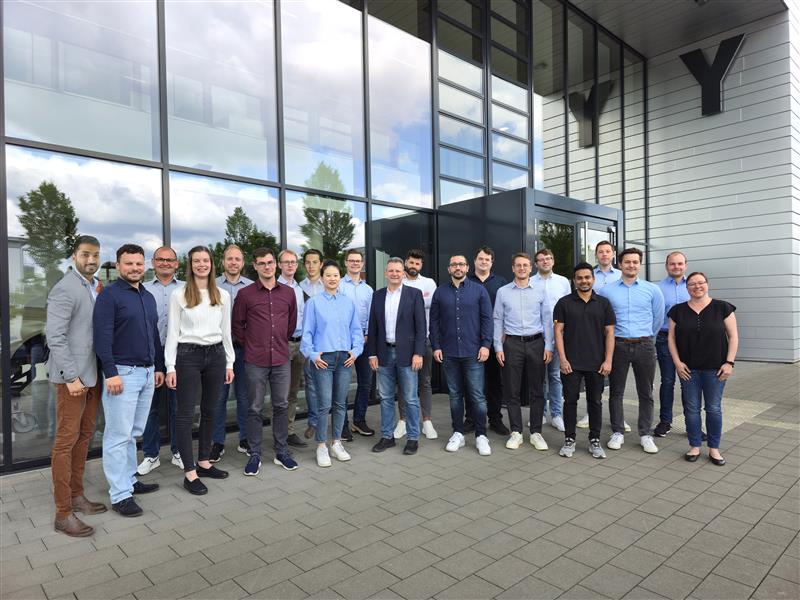 Mitarbeitende des Lehrstuhls für Leichtbau im Automobil stehen vor dem Y-Gebäude auf dem Campus der Uni Paderborn